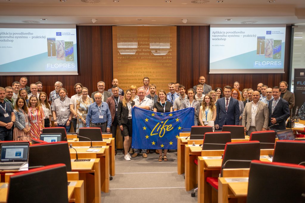 fotografia účastníkov odborného podujatia FLOPRES - v popredí vlajka programu LIFE