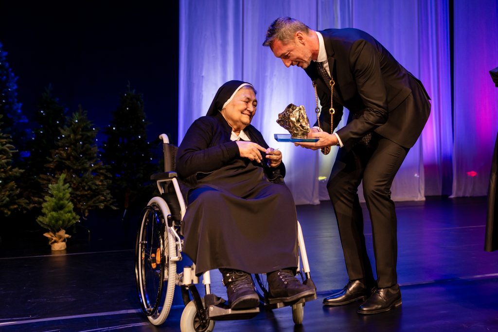 Rehoľná sestra Maristella si preberá cenu od predsedu M. Majerského