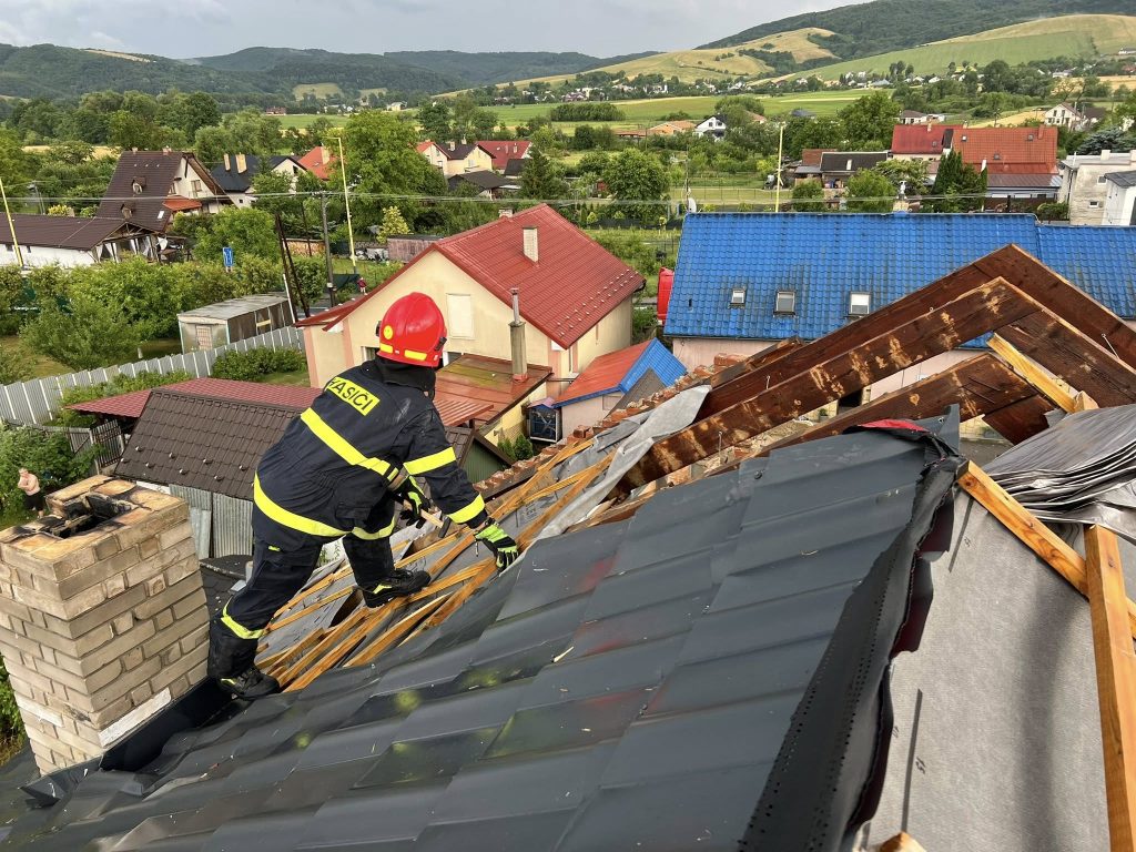 V obci Kračúnovce vznikli rozsiahle škody, hasič na streche domu